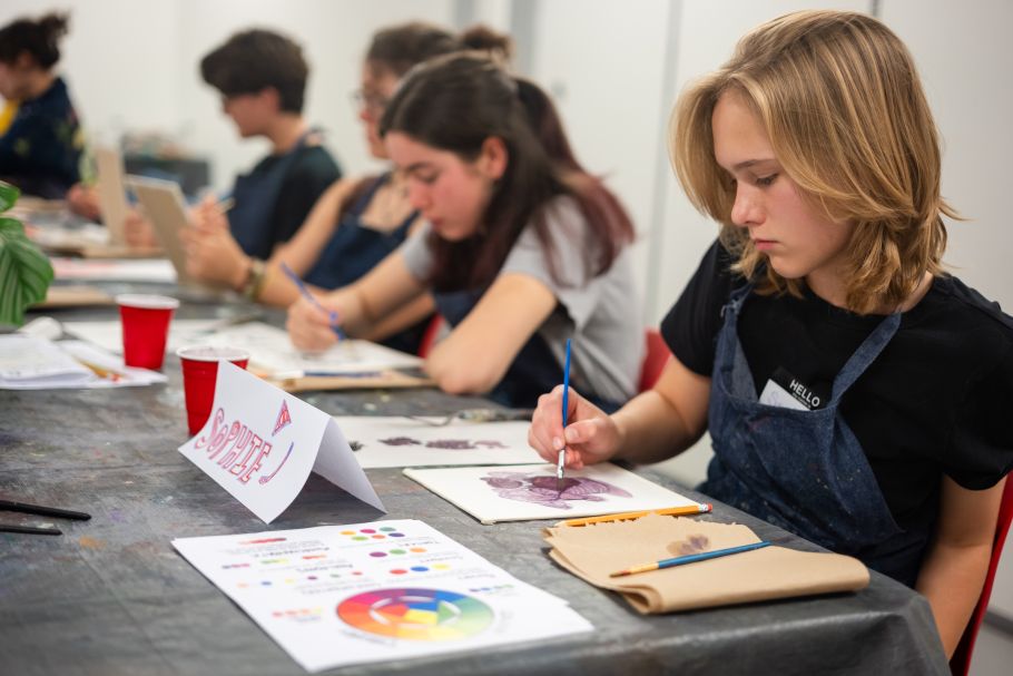Teenagers sit at a long table oil painting. 