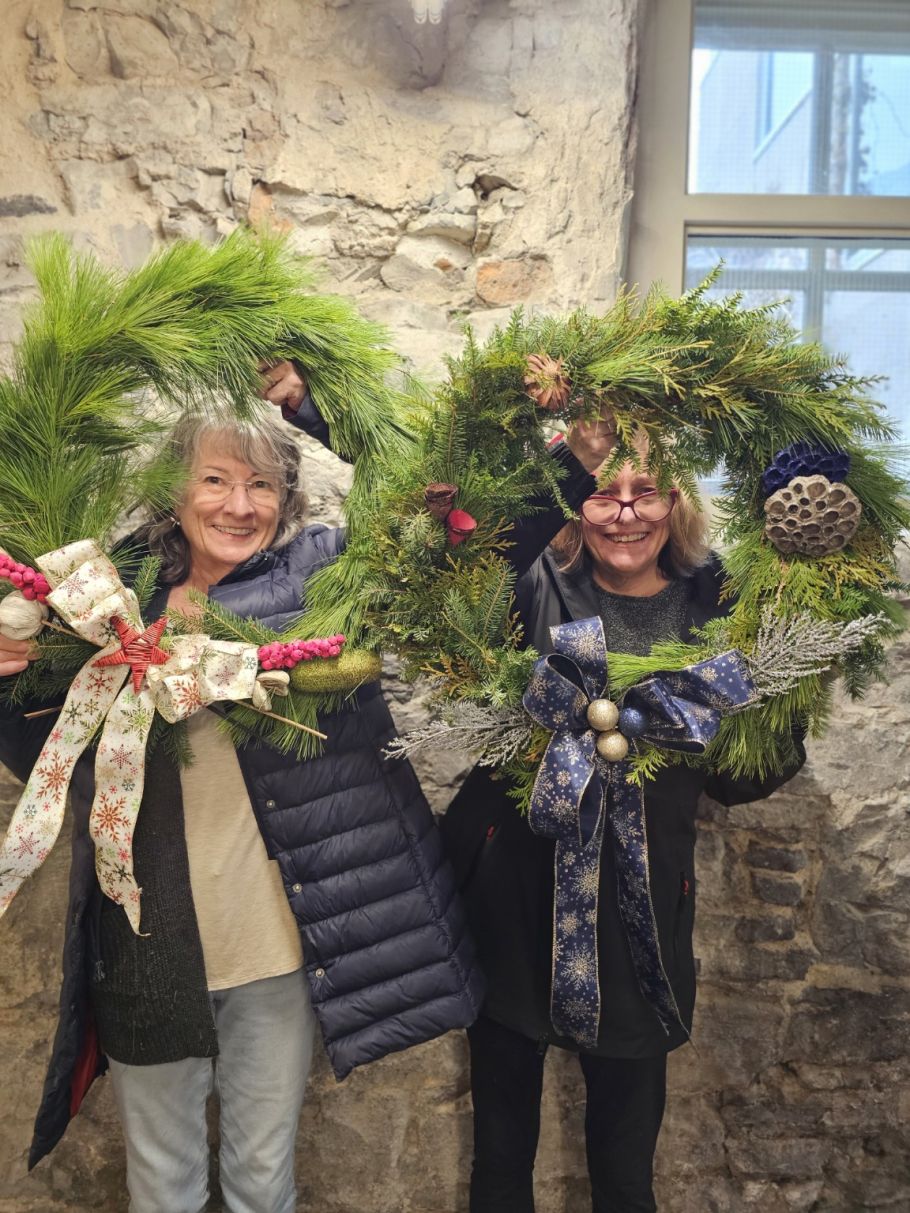 Two participants stand with their wreaths