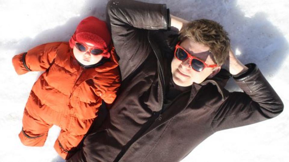 Baby and Man relaxing in the snow