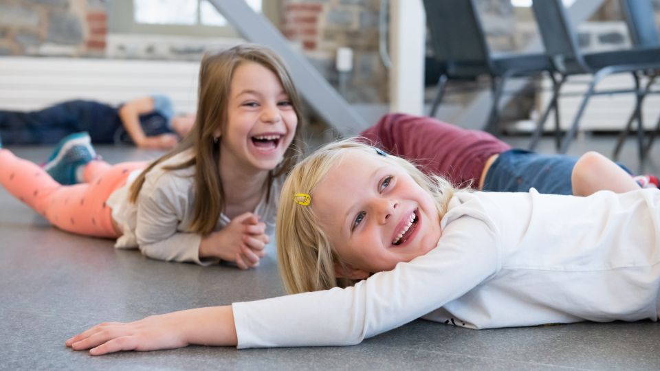 Children lay on the floor laughing