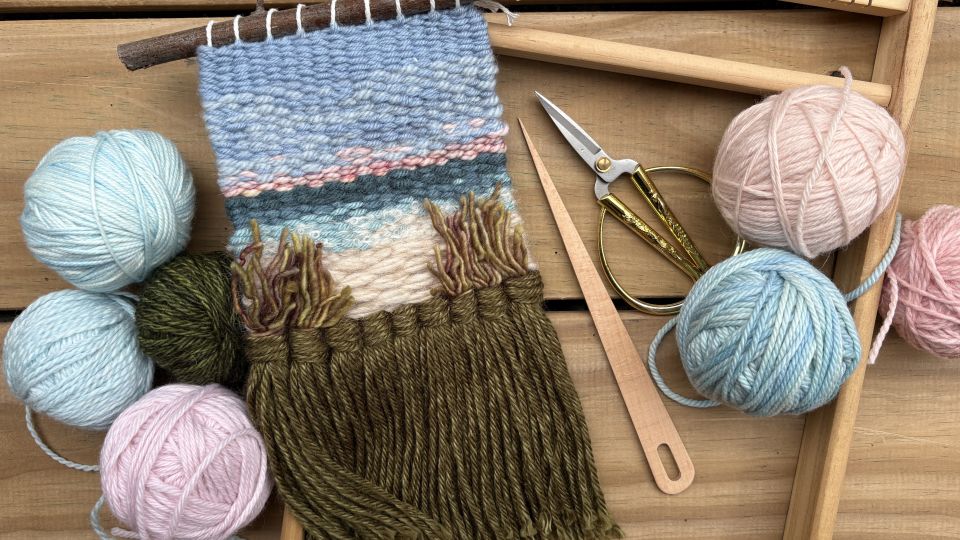 Weaving example of a landscape with yarn next to it